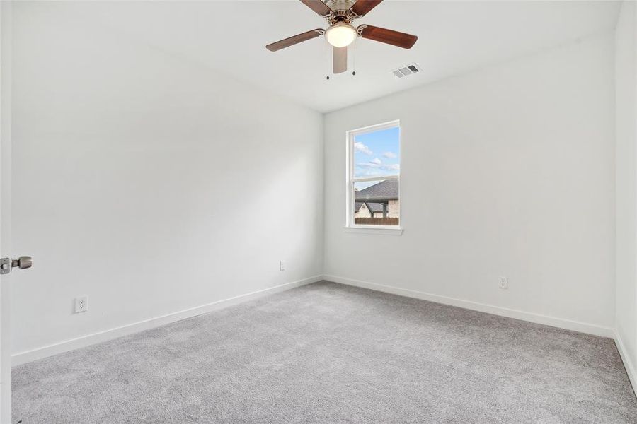 Empty room featuring light colored carpet and ceiling fan