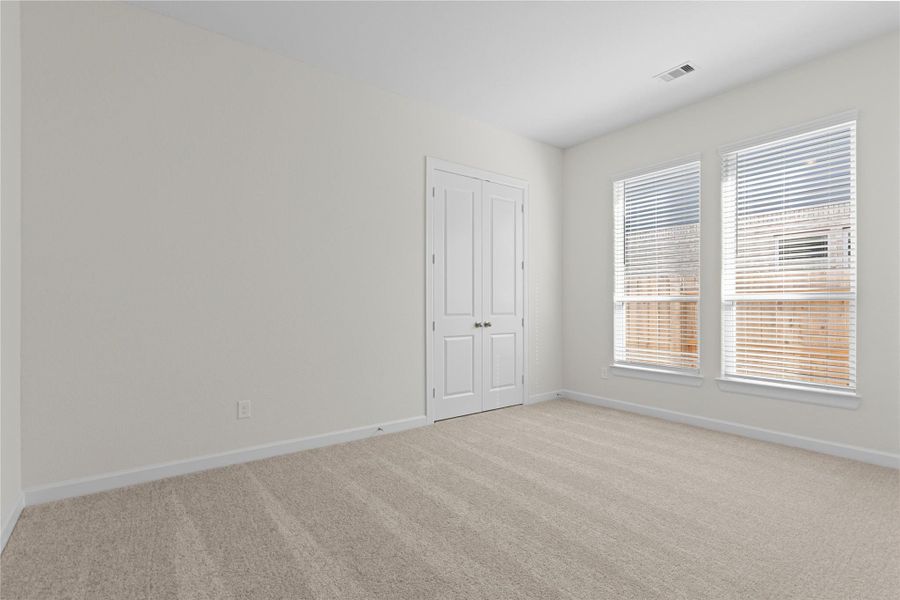 This additional bedroom offers versatility and comfort with soft carpeting, large windows for natural light, and a welcoming layout, ideal for a guest suite, home office, or flexible living space to suit your needs.
