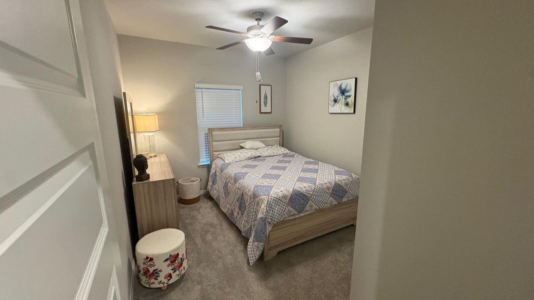 Well-lit sleeping quarters with a ceiling fan for comfort.