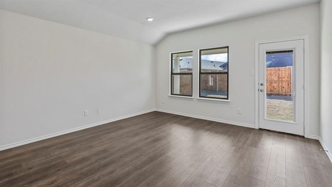 Unfurnished room featuring dark wood finished floors and lofted ceiling Unfurnished room featuring dark wood finished floors and lofted ceiling