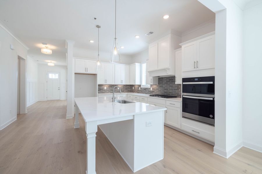 The kitchen features a large center island and elegent designer cabinets