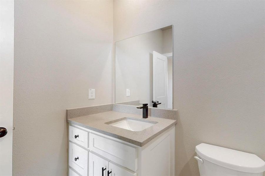 Half bathroom with toilet and vanity