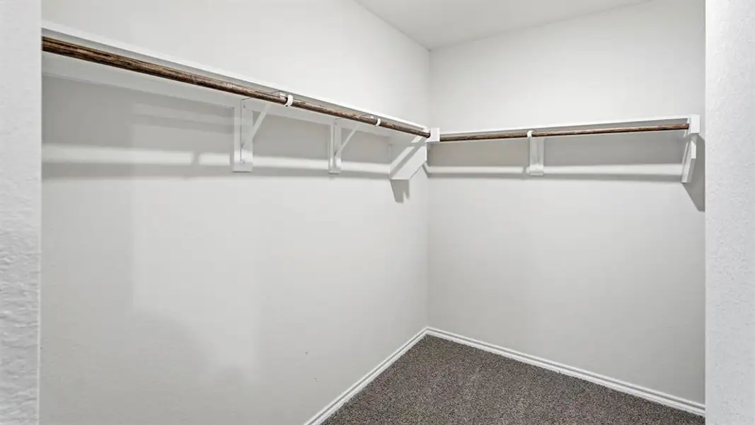 Walk in closet with dark carpet
