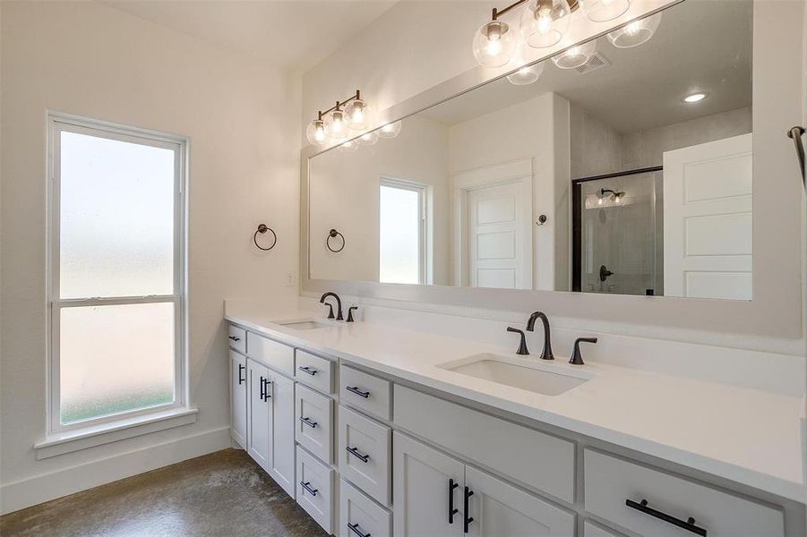 Bathroom with vanity, walk in shower, and concrete flooring