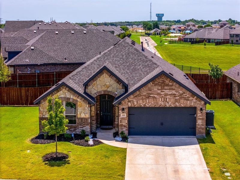 French provincial home featuring a residential view, driveway, stone siding, and brick siding