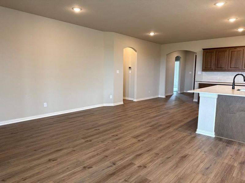 Expansive interior space featuring wood-finish flooring, recessed lighting, and arched doorways