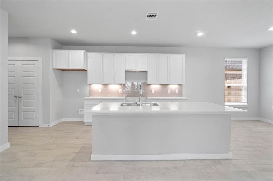 This kitchen is by far any chef’s dream! This spacious kitchen features high ceilings, white stained wood cabinets, quartz countertops, SS appliances, modern tile backsplash, recessed lighting, extended counter space, quartz kitchen island with space for breakfast bar, and a walk-in pantry all overlooking your huge family room.