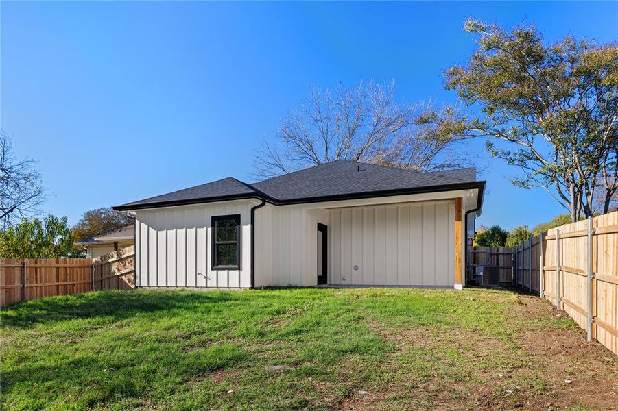 Back of house featuring a fenced backyard, board and batten siding, and a shingled roof