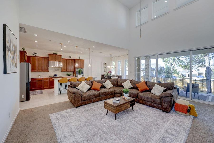 Living room featuring light carpet, recessed lighting, a high ceiling, and light tile patterned floors