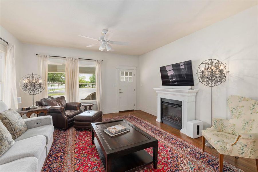 Living area featuring hardwood-finish flooring and a white ceiling fan