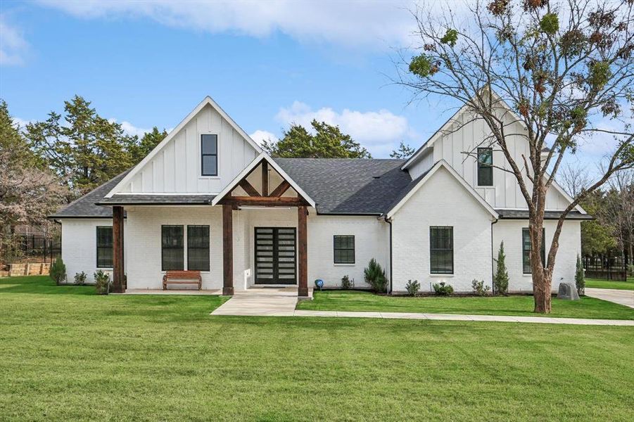 Modern farmhouse style home with a front yard