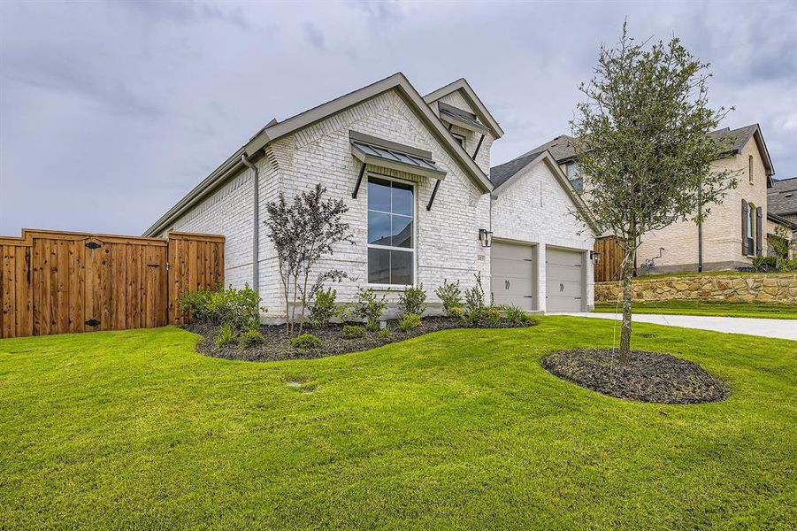 View of front of property featuring driveway, a garage, and brick siding