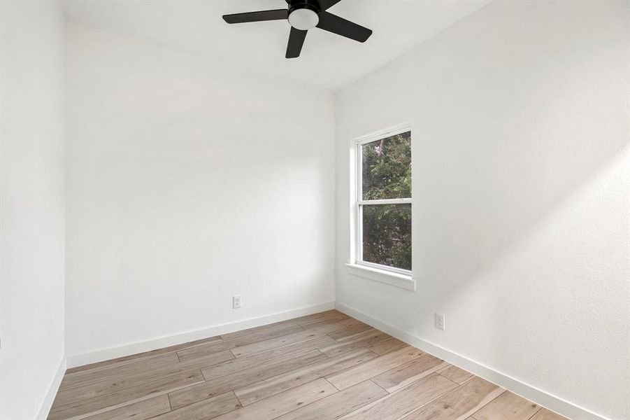 Unfurnished room featuring ceiling fan, light wood-style flooring, and baseboards Unfurnished room featuring ceiling fan, light wood-style flooring, and baseboards