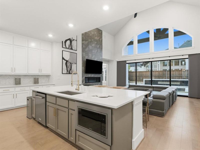 Open-concept living area featuring a vaulted ceiling and an expansive arched window ensemble Open-concept living area featuring a vaulted ceiling and an expansive arched window ensemble