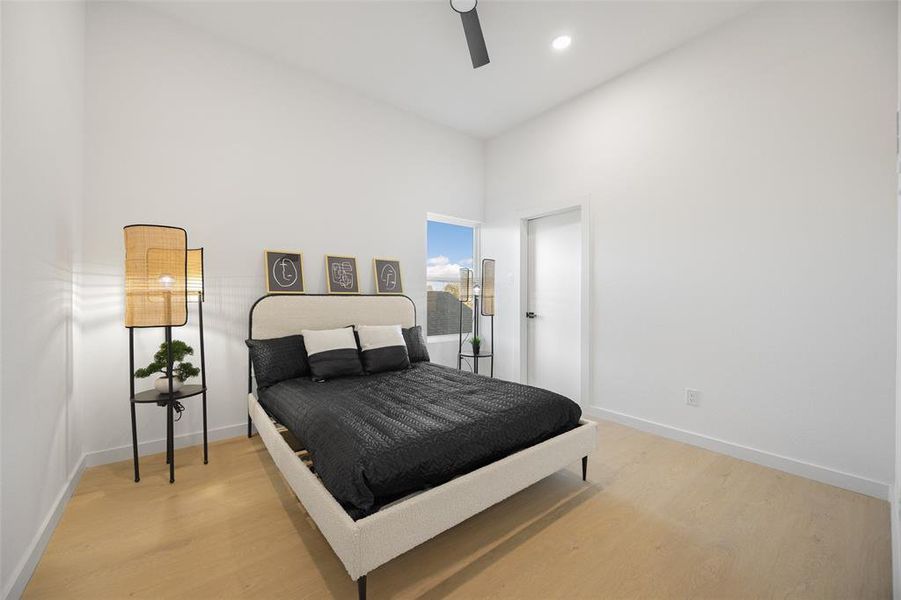 Bedroom with light wood-style flooring, a ceiling fan, and recessed lighting