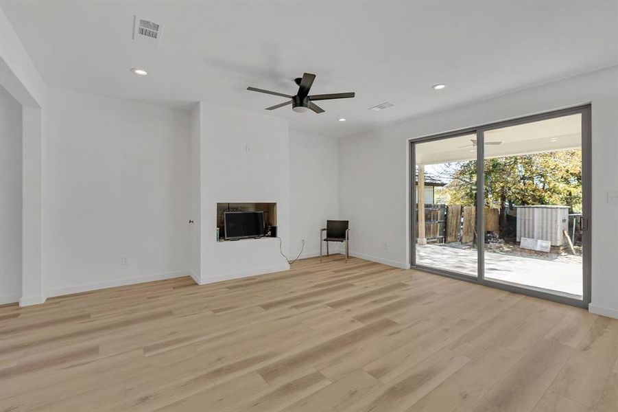 Unfurnished living room featuring light wood-style floors, a fireplace, recessed lighting, and ceiling fan