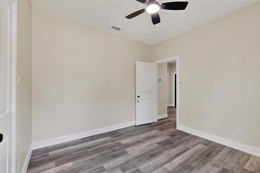 Unfurnished room featuring wood finished floors and a ceiling fan Unfurnished room featuring wood finished floors and a ceiling fan