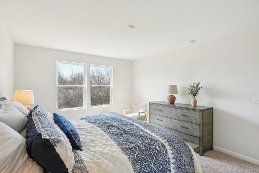 A bedroom with a bed and dresser.