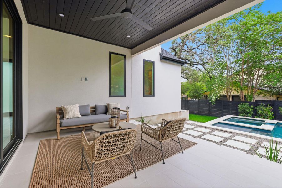Covered patio with a dark wood plank ceiling and recessed lighting