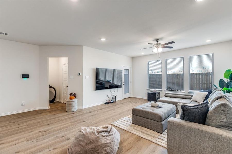 Living area featuring light wood-style floors, recessed lighting, and a ceiling fan Living area featuring light wood-style floors, recessed lighting, and a ceiling fan