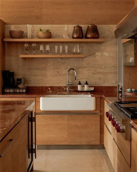 Kitchen featuring dark countertops, stainless steel gas cooktop, modern cabinets, open shelves, and beverage cooler