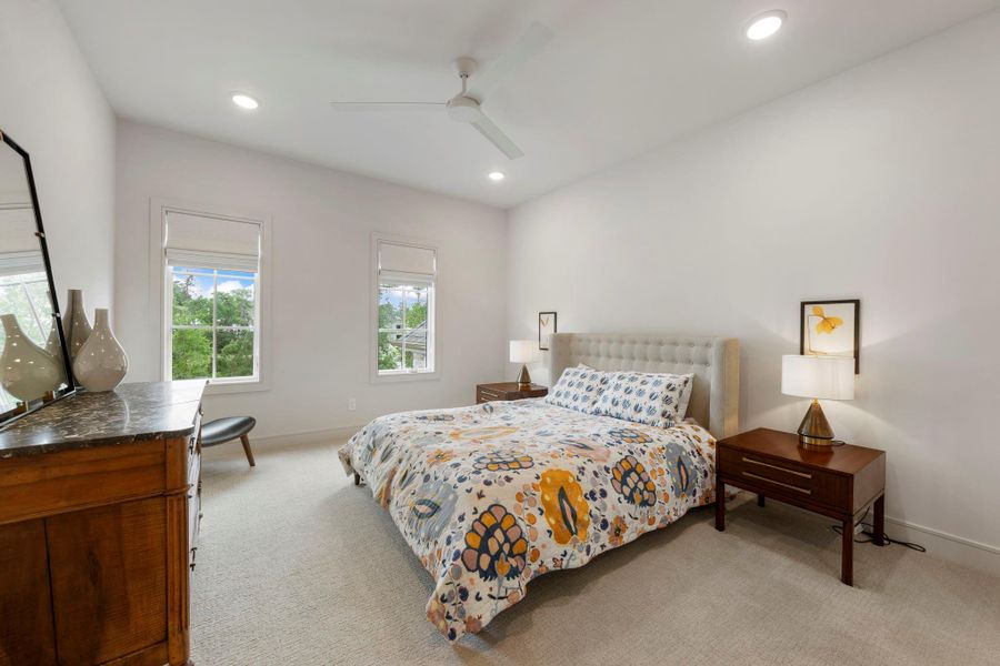 Well-appointed guest bedroom with abundant natural light, soft carpeting, and serene backyard views—perfect for visiting family and friends.