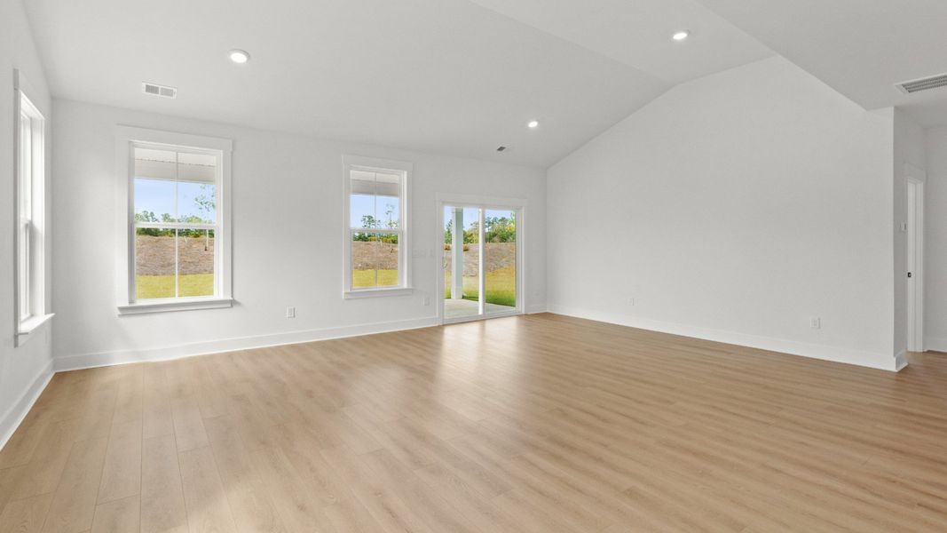 Expansive living area with vaulted ceiling and access to the rear porch.