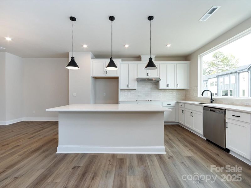 Crisp White Cabinetry and Cream Glossy Backsplash.