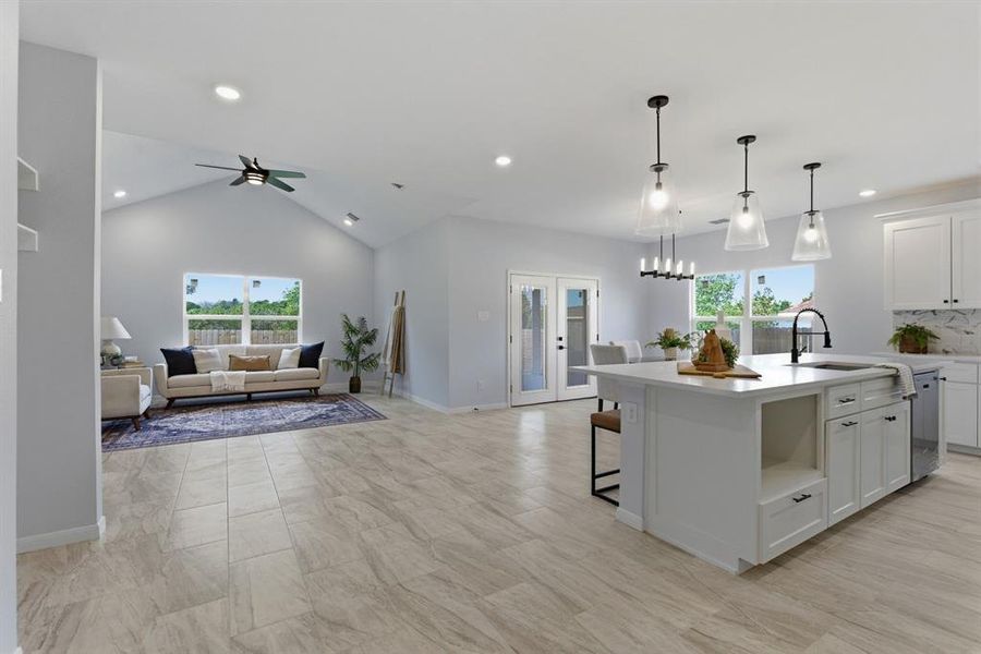 Kitchen with open floor plan, white cabinetry, a kitchen breakfast bar, an island with sink, and healthy amount of natural light Kitchen with open floor plan, white cabinetry, a kitchen breakfast bar, an island with sink, and healthy amount of natural light