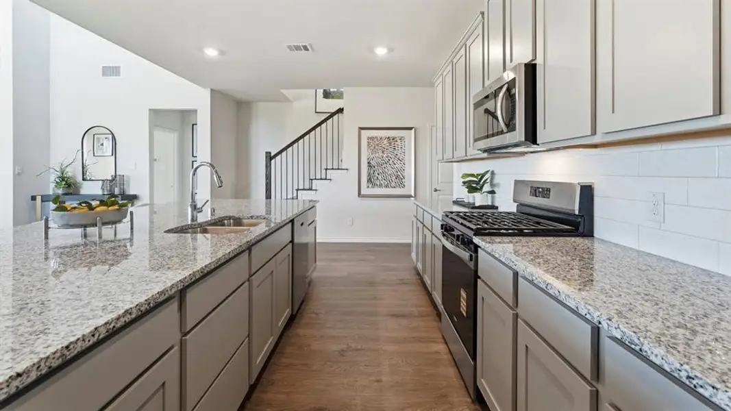 Kitchen featuring stainless steel appliances, gray cabinetry, dark wood-style flooring, light stone counters, and recessed lighting