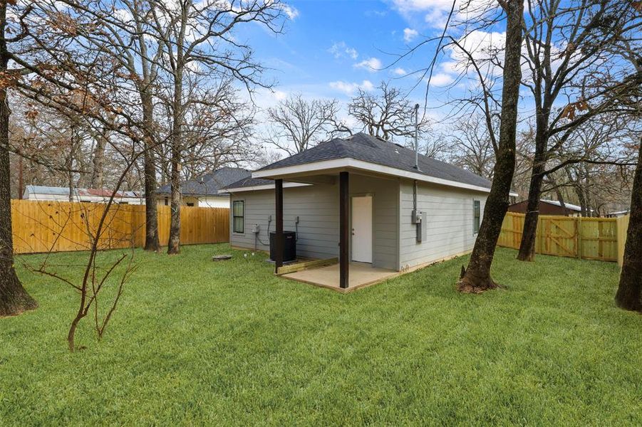 Back of house with a patio, a yard, and central AC