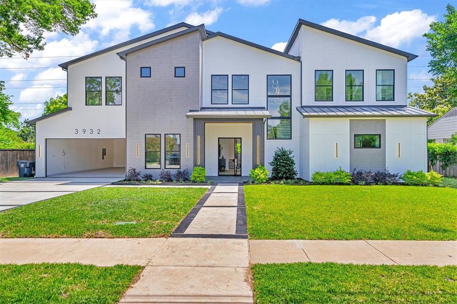 View of front of property featuring a garage and a front yard