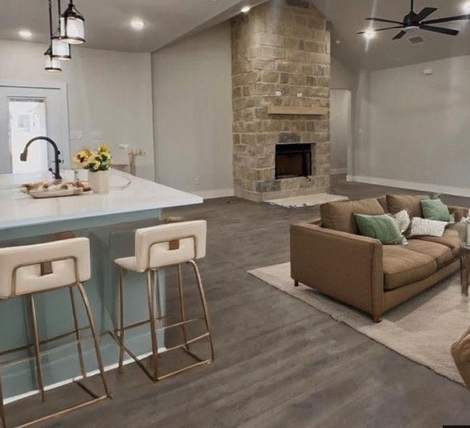 Bar area featuring pendant lighting, a fireplace, ceiling fan, recessed lighting, and lofted ceiling
