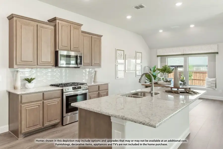 Kitchen with large granite island, tan cabinets, stainless steel appliances, and white tile backsplash