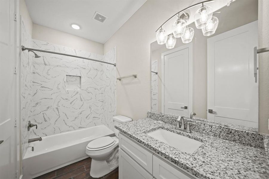 Secondary Bathroom with tile floors, a shower/tub combo, granite countertops, and a large mirror.