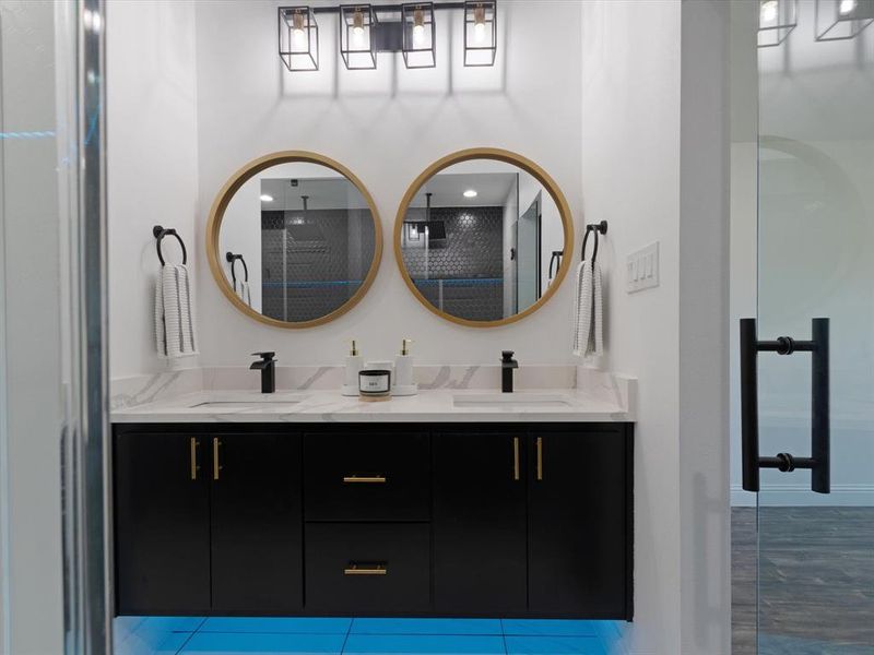 Bathroom featuring a shower with door and vanity