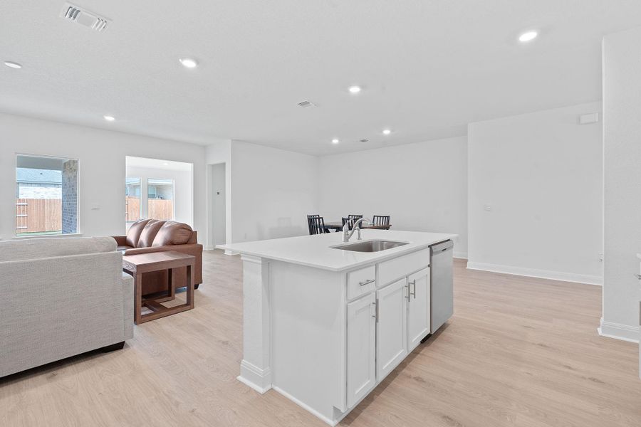 Kitchen with open floor plan, white cabinets, light wood-type flooring, an island with sink, and recessed lighting Kitchen with open floor plan, white cabinets, light wood-type flooring, an island with sink, and recessed lighting