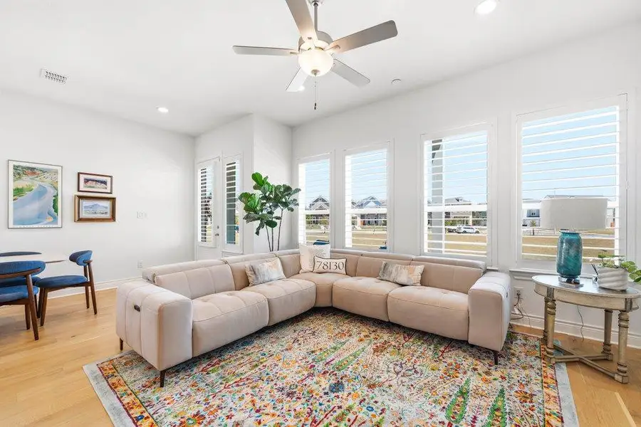 Rich hardwood floors and plantation shutters frame this airy living area. Rich hardwood floors and plantation shutters frame this airy living area.