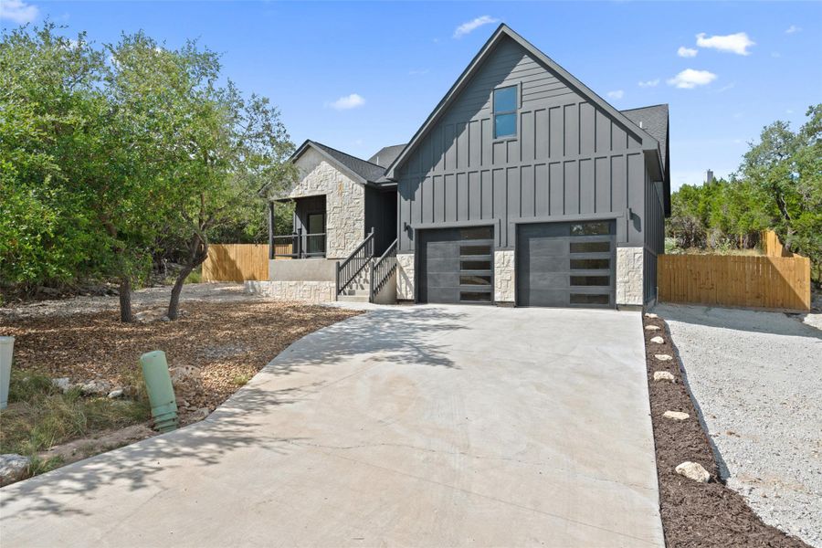 View of front of house featuring stone siding, board and batten siding, concrete driveway, and a garage View of front of house featuring stone siding, board and batten siding, concrete driveway, and a garage