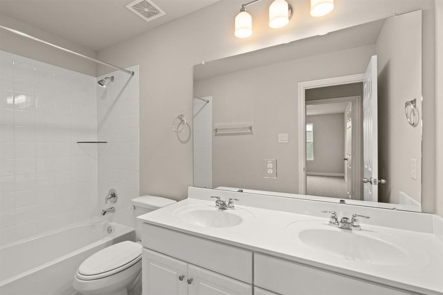 The secondary bath features tile flooring, white cabinetry and light countertops and a shower/tub combo. Perfect for accommodating any visiting family and friends.