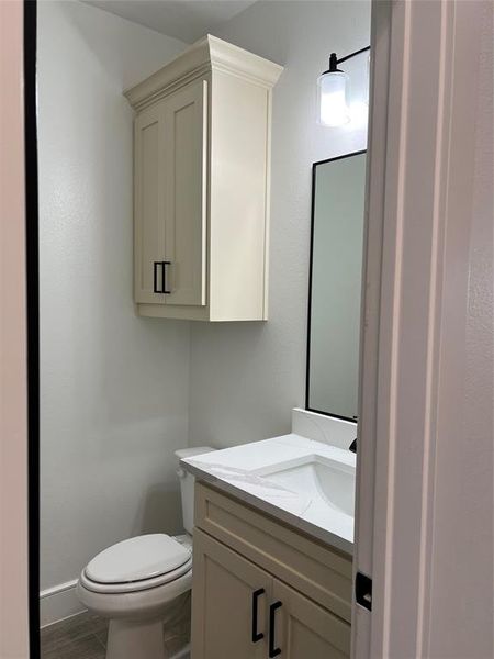 Half bathroom featuring vanity and wood finished floors