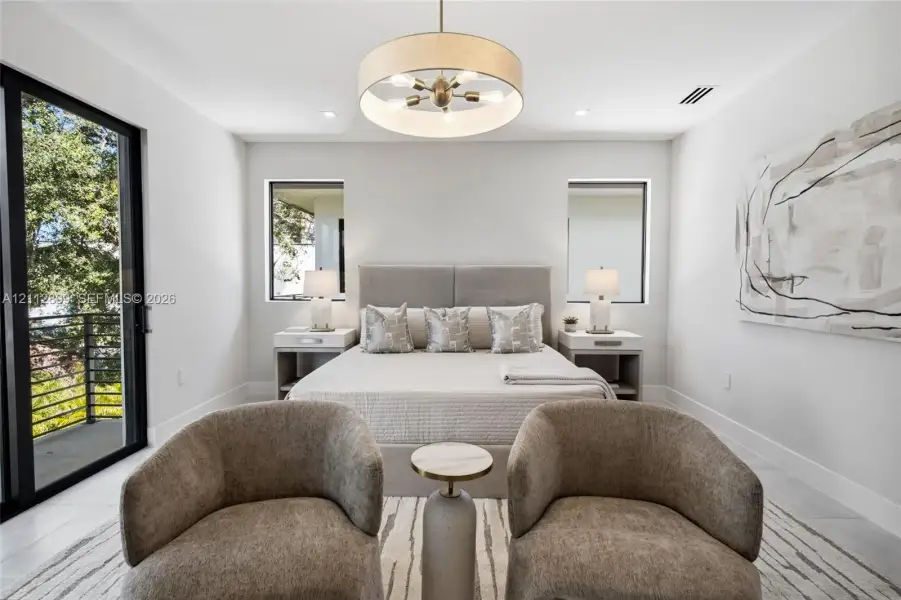 Bedroom featuring large-format tile flooring, a multi-bulb drum pendant light fixture, and black-framed sliding glass doors opening to a balcony