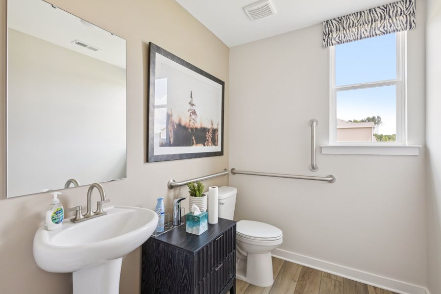 A bathroom with a sink toilet and a mirror. A bathroom with a sink toilet and a mirror.