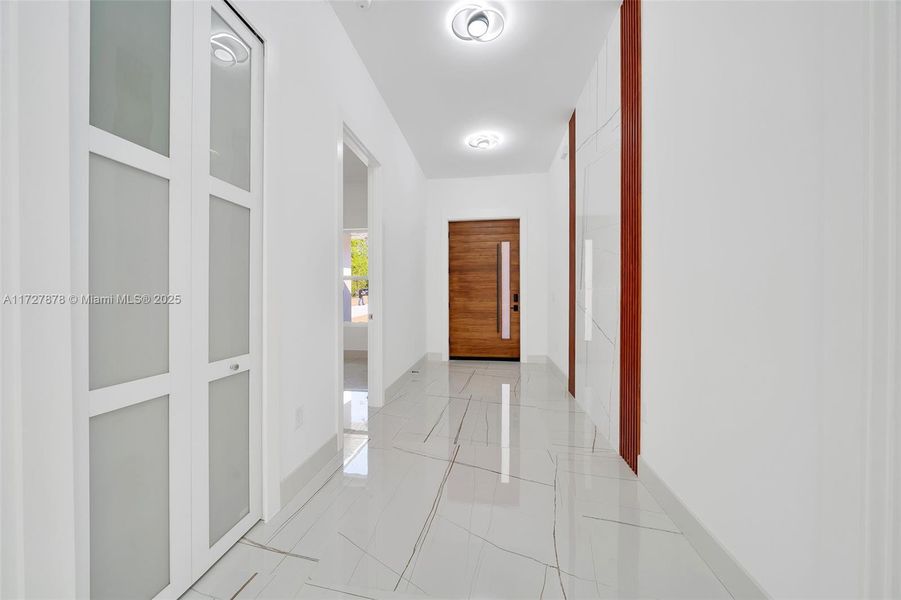 FOYER WITH WATERFALL OF TILE TRIMMED WITH MAHOGANY ACOUSTIC PANELS