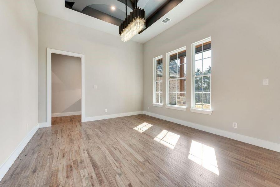 Spare room featuring a notable chandelier and light hardwood / wood-style flooring