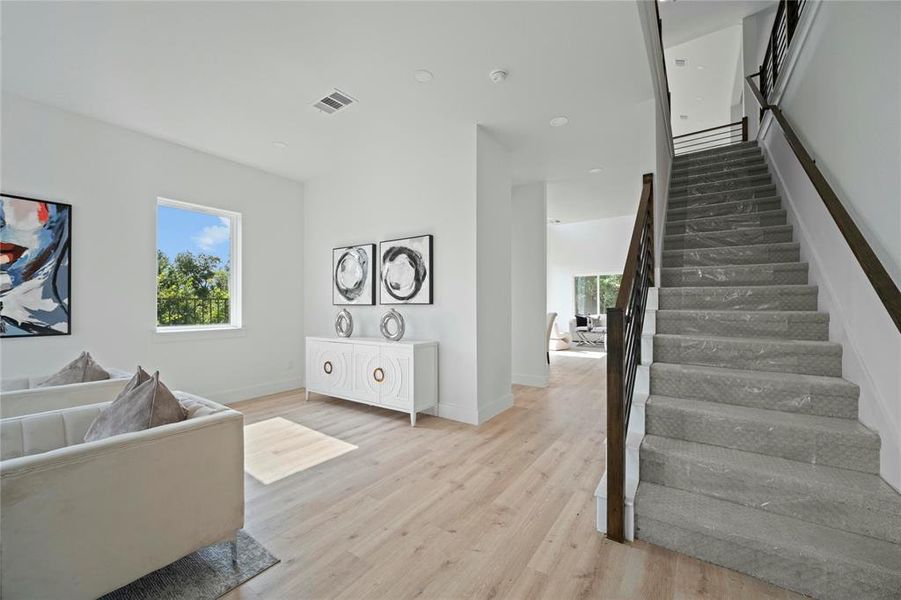 Living area featuring stairs and wood finished floors Living area featuring stairs and wood finished floors