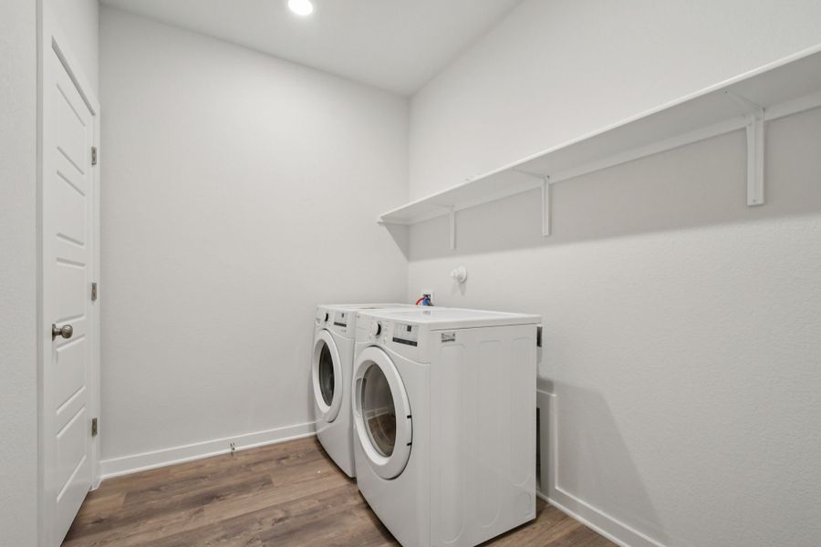 A white room with a washing machine and a white wall.