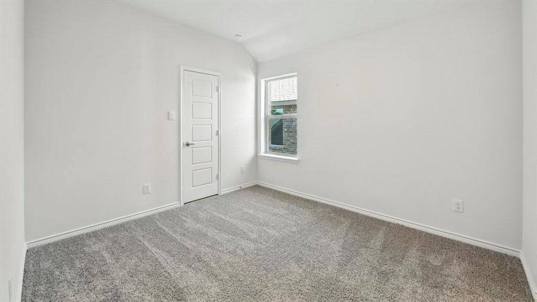 Unfurnished room featuring carpet floors and lofted ceiling Unfurnished room featuring carpet floors and lofted ceiling