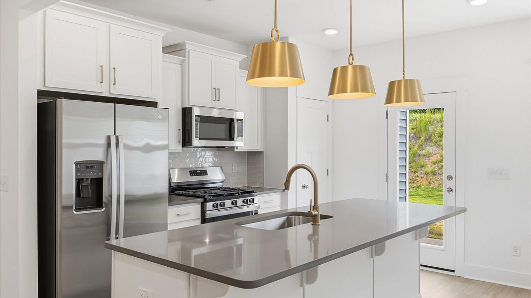 Tasteful kitchen with a streamlined island and modern finishes in a first-class DRB Homes design Tasteful kitchen with a streamlined island and modern finishes in a first-class DRB Homes design