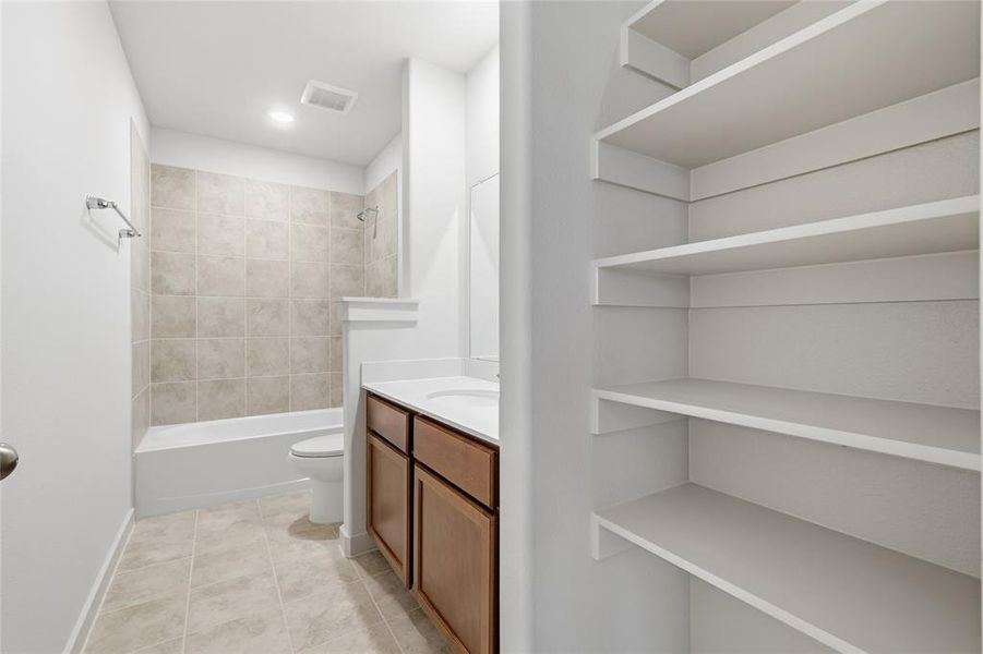 Full bath with vanity, shower / bath combination, light tile patterned floors, and recessed lighting Full bath with vanity, shower / bath combination, light tile patterned floors, and recessed lighting